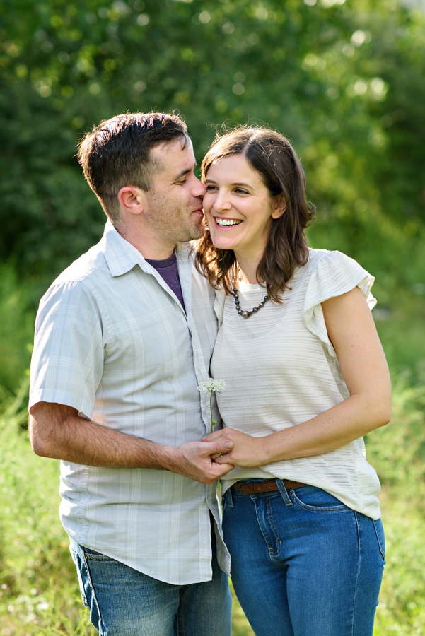 A man picks flowers for his loving fiance during their engagement session in Fishtown.